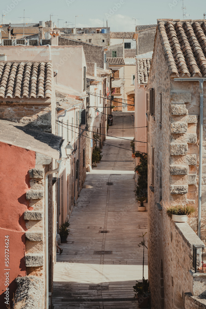 Old narrow street with colorful houses in old town, Alcudia, Mallorca, Spain. 