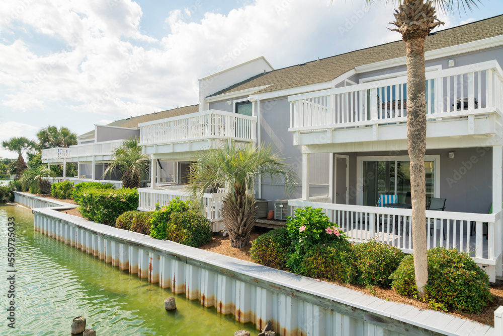 Row of houses with balconies near the steel retaining wall of a lake with brackish water- Destin, FL Row of houses with balconies near the steel retaining wall of a lake with brackish water- Destin, FL