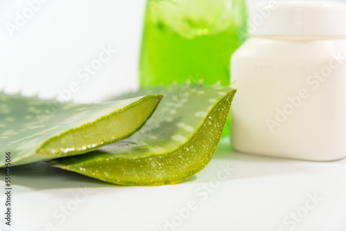 Aloe Vera leaves, plastic container and detergent bottle on a table