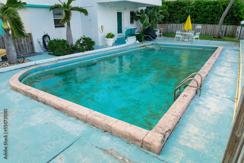 Bild auf Leinwand Dirty outdoor private pool with algae near the plants and trees outside the buil