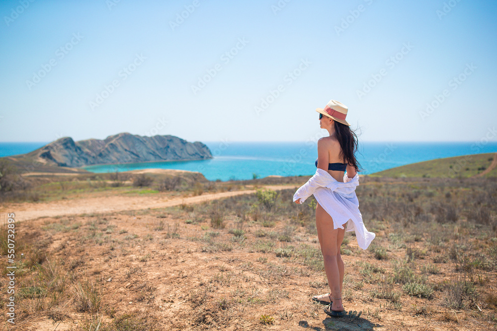 Tourist woman outdoor on edge of cliff seashore