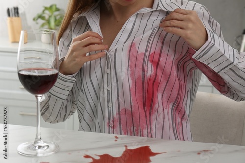 Schilderij op canvas Woman with spilled wine over her shirt and marble table in kitchen, closeup