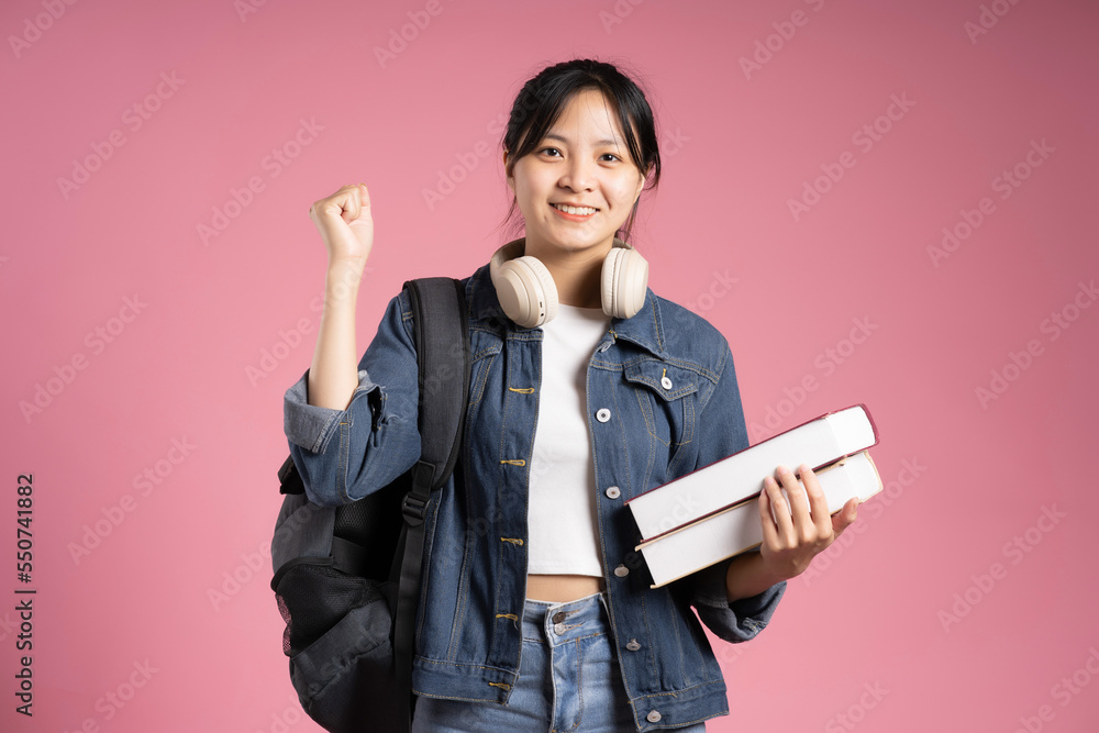 Asian girl student posing on pink background Asian girl student posing on pink background