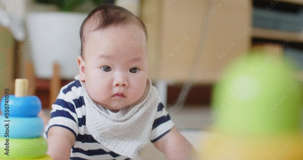 happy little cute Asian baby girl learning trying to crawl on floor with toy in the room, baby exploring home curious infant having fun enjoying childhood happy little cute Asian baby girl learning trying to crawl on floor with toy in the room, baby exploring home curious infant having fun enjoying childhood