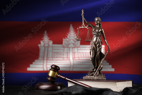 Cambodia flag with statue of lady justice, constitution and judge hammer on black drapery. Concept of judgement and punishment photo