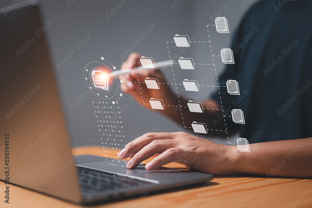 A businessman uses a computer to learn about document management concepts, online documentation databases, digital file storage systems, database technology, file access, and document sharing. A businessman uses a computer to learn about document management concepts, online documentation databases, digital file storage systems, database technology, file access, and document sharing.