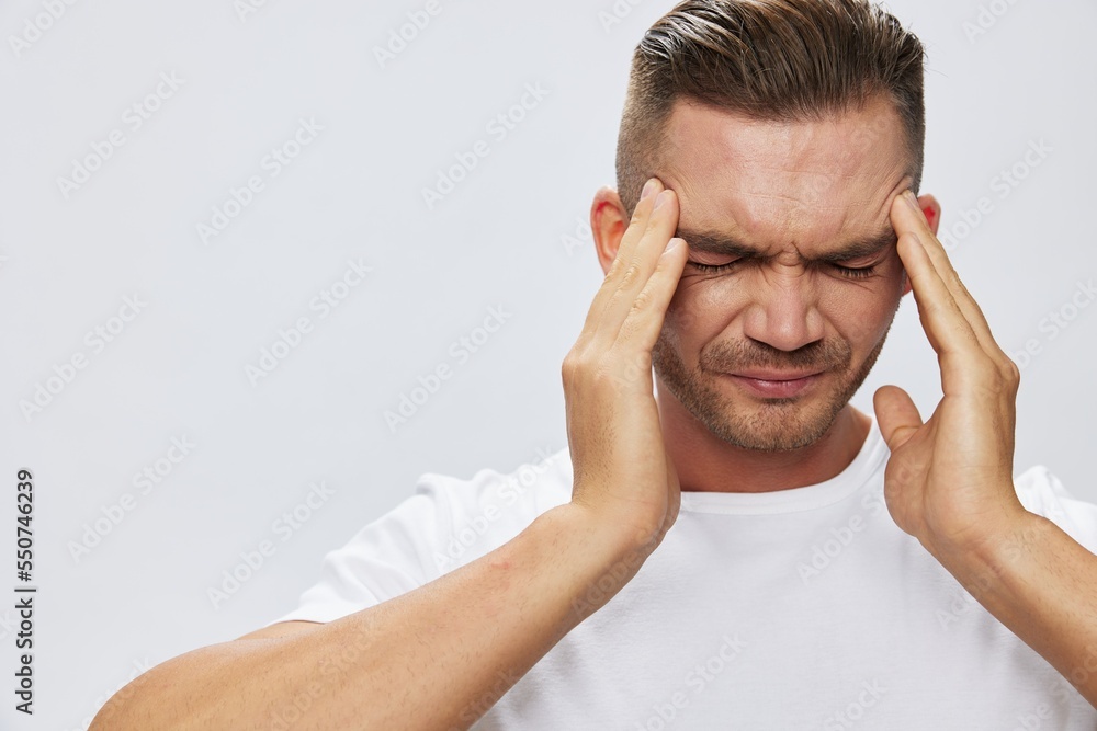Man headache, migraine, high fever, in white T-shirt on white isolated background, copy space Man headache, migraine, high fever, in white T-shirt on white isolated background, copy space