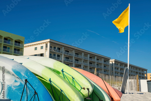 Kayak rentals near the yellow flag on a pole at the front of hotel buildings in Destin, Florida