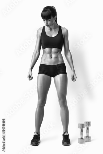 Fit female athlete in activewear ready to doing exercise with dumbbells