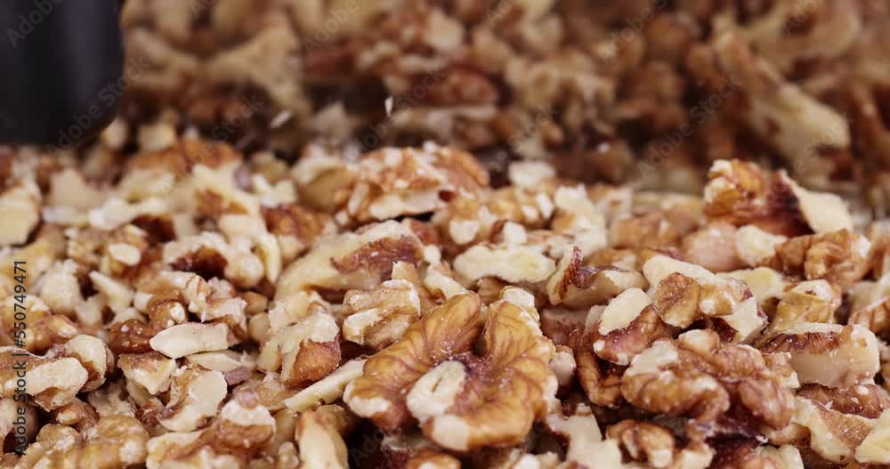 Cut walnuts on a board, cut ripe walnuts into pieces for use in confectionery Cut walnuts on a board, cut ripe walnuts into pieces for use in confectionery