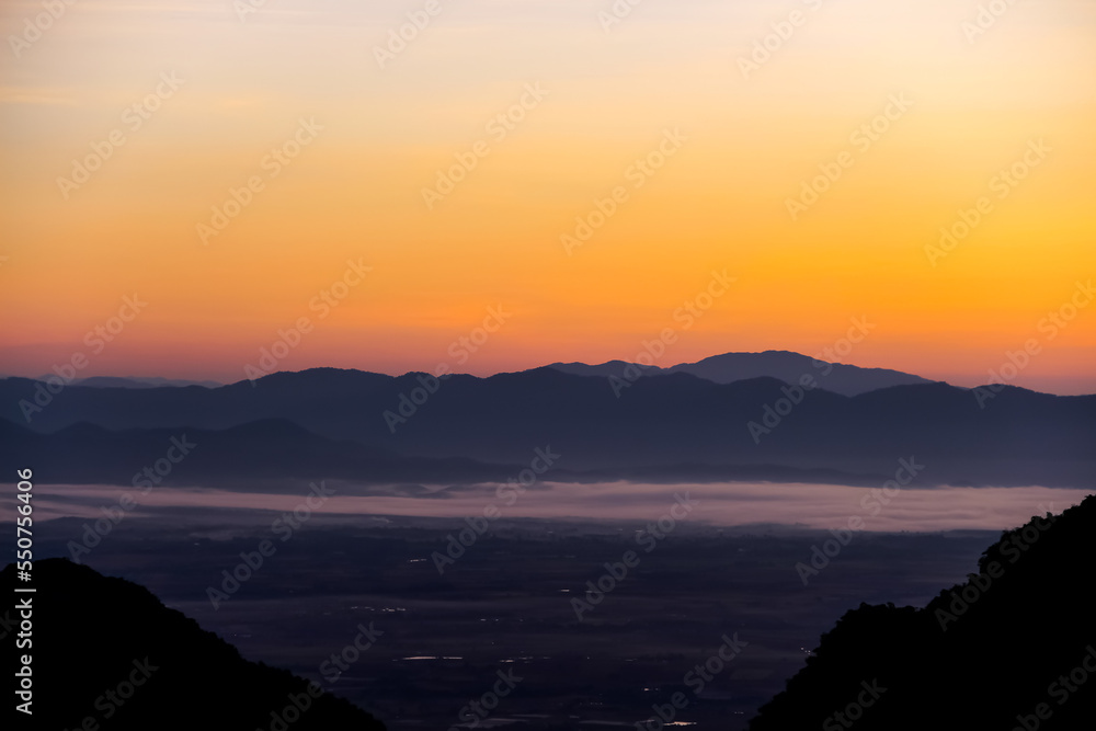 Mountains view on beautiful orange gold sky  before sunrise in the morning Chiang Rai of Thailand background