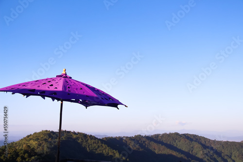Big purple fabric umbrella on  blue sky and mountain view outdoor background