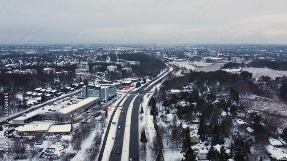 Mid sized road leading towards the city center on a snowy day. Turku, Finland. Dolly forward drone shot Mid sized road leading towards the city center on a snowy day. Turku, Finland. Dolly forward drone shot