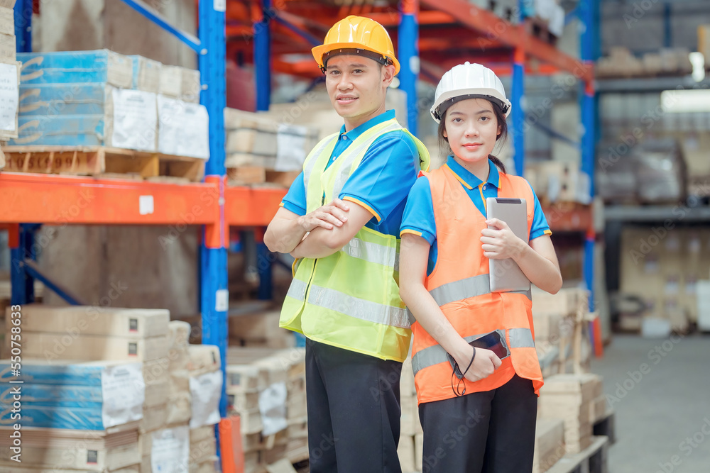 Portrait asian engineer in helmets order on tablet for checking goods and supplies on shelves with goods background in warehouse.logistic business export ,Warehouse worker checking packages on store Portrait asian engineer in helmets order on tablet for checking goods and supplies on shelves with goods background in warehouse.logistic business export ,Warehouse worker checking packages on store