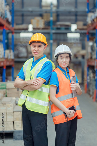 Portrait asian engineer in helmets order on tablet for checking goods and supplies on shelves with goods background in warehouse.logistic business export ,Warehouse worker checking packages on store