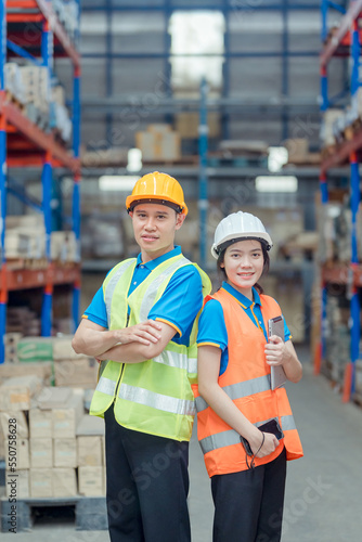 Portrait asian engineer in helmets order on tablet for checking goods and supplies on shelves with goods background in warehouse.logistic business export ,Warehouse worker checking packages on store