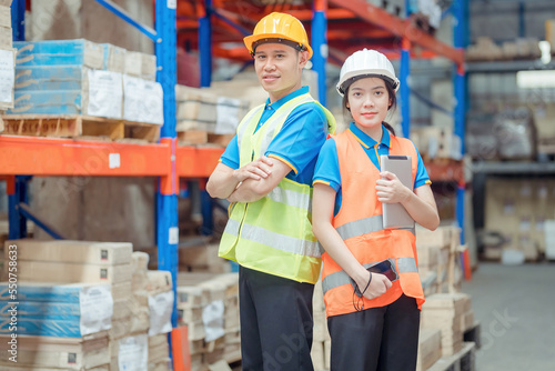 Portrait asian engineer in helmets order on tablet for checking goods and supplies on shelves with goods background in warehouse.logistic business export ,Warehouse worker checking packages on store