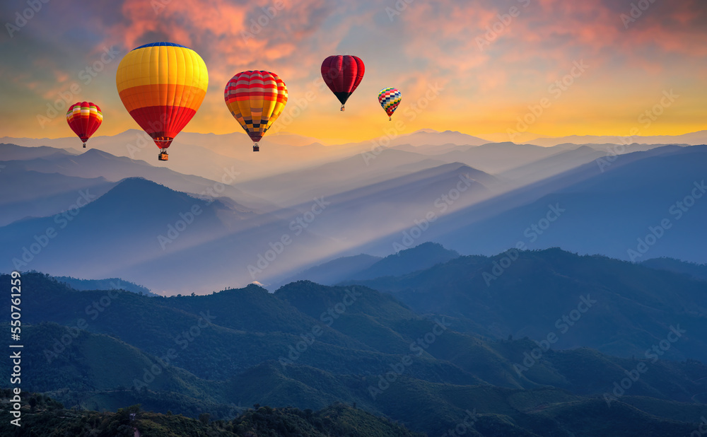 Colorful hot air balloons flying above high mountain at sunrise with beautiful sky background. aerial from Doi Pui Co, Mae Hong Son in Thailand