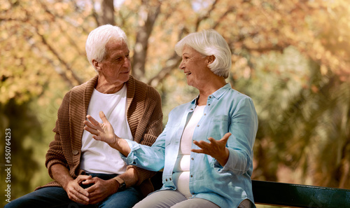 Nature, park and retirement with a senior couple sitting together on a wooden bench outdoor in a garden. Spring, love and summer with a mature man and woman bonding outside in the countryside © Anela/peopleimages.com