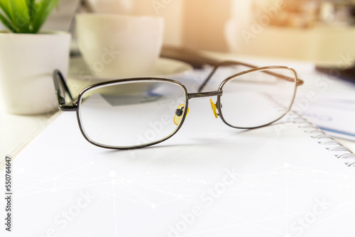 businessman glasses on a white notebook on the desk,investment business vision