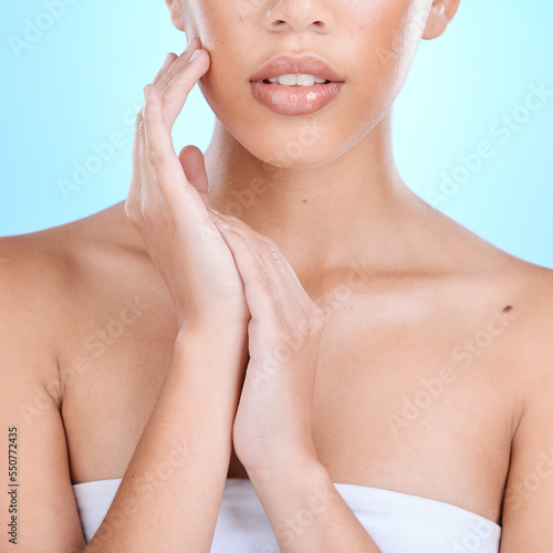 Beauty, skincare and lips with gloss, shine and lipstick with hands on body for cosmetic, makeup and dermatology advertising on blue studio background. Zoom aesthetic model mouth with glow on skin