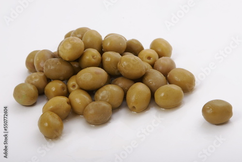 Fresh wet olives on a white surface
