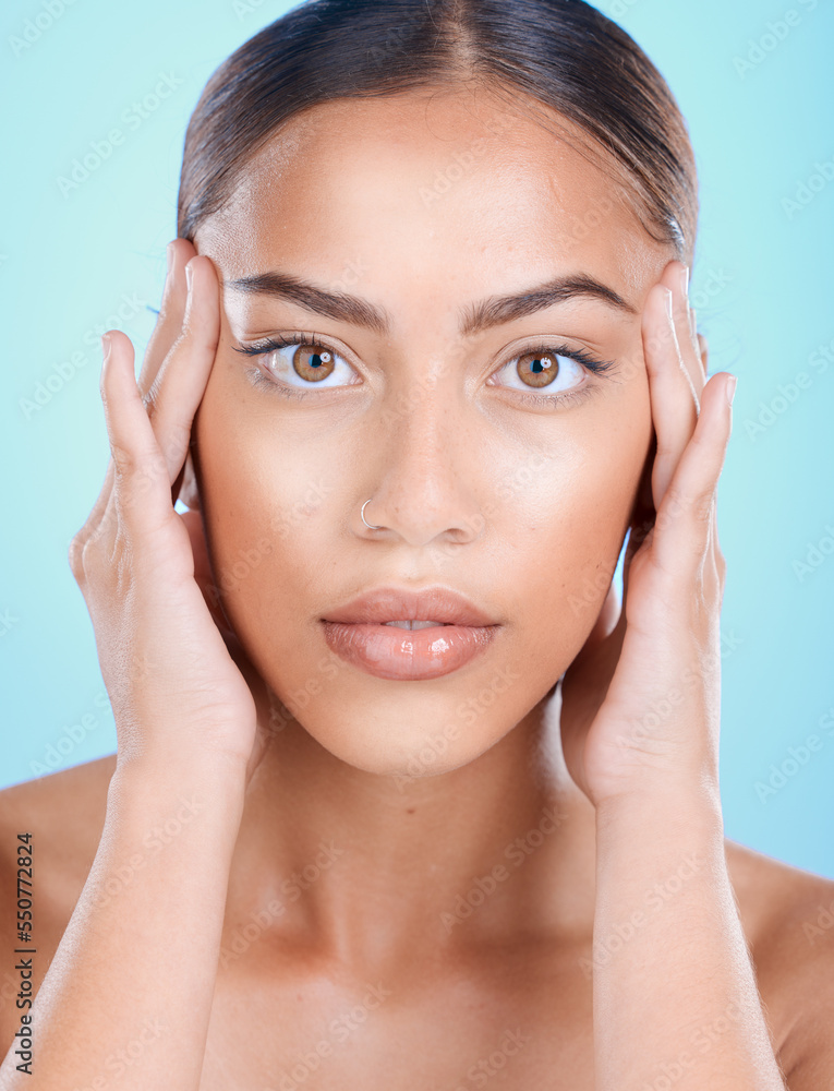Portrait, face and beauty with a model black woman touching her skin in studio on a blue background. Skincare, cosmetics and antiaging with an attractive young female posing for natural treatment