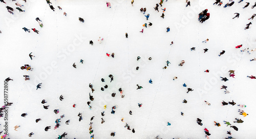 People Skating on an Open-Air Ice Skating Rink. Top view. Many People Skating on Ice of Rink. Aerial Drone View. Beautiful Skating Sport and Winter Outdoor Activities Background