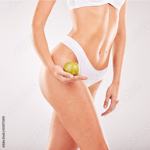 Skincare, apple and body of woman in lingerie in studio isolated on gray background mockup. Food, underwear and female model holding healthy fruit for diet, nutrition or vitamin c, wellness or beauty photo