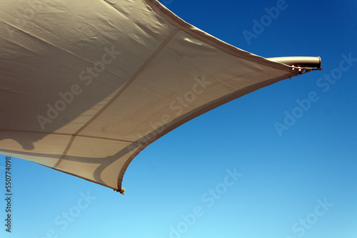 fragment of a stretched awning against the blue sky, copy space