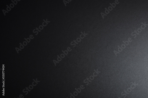 Black textured surface, side lighting. Dark empty background, top view