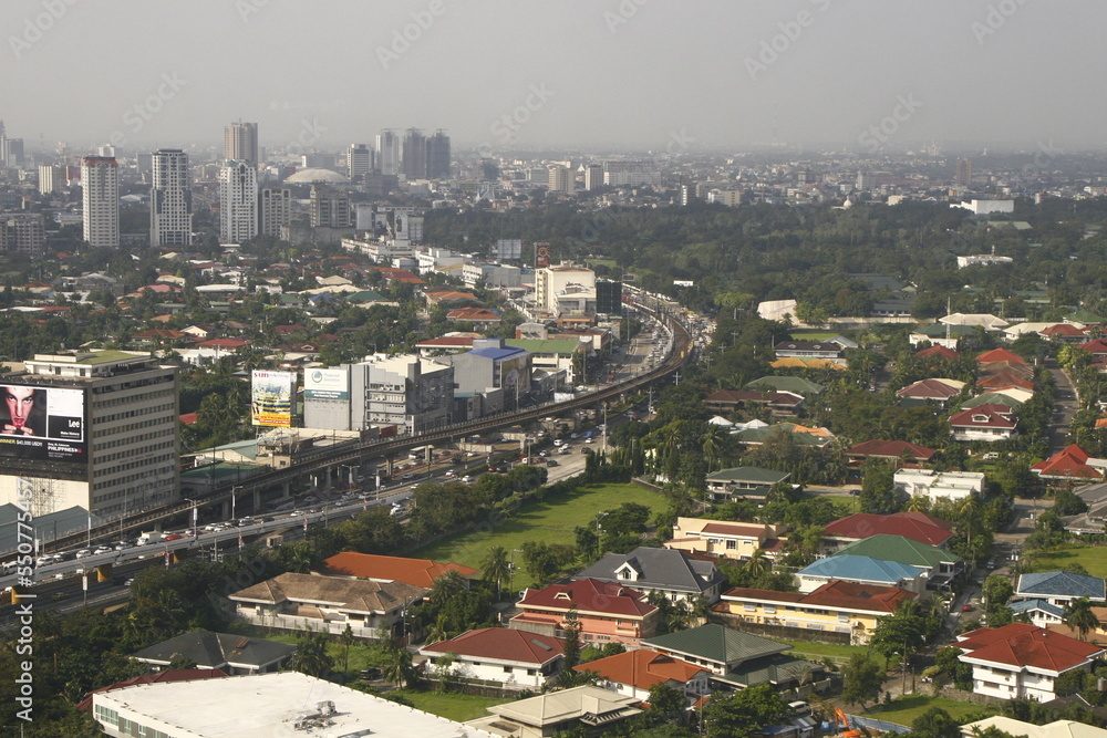 Fototapeta premium View of EDSA highway with residential houses, trees and buildings in the distance
