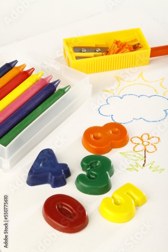 School materials on top of a child's colorful drawing