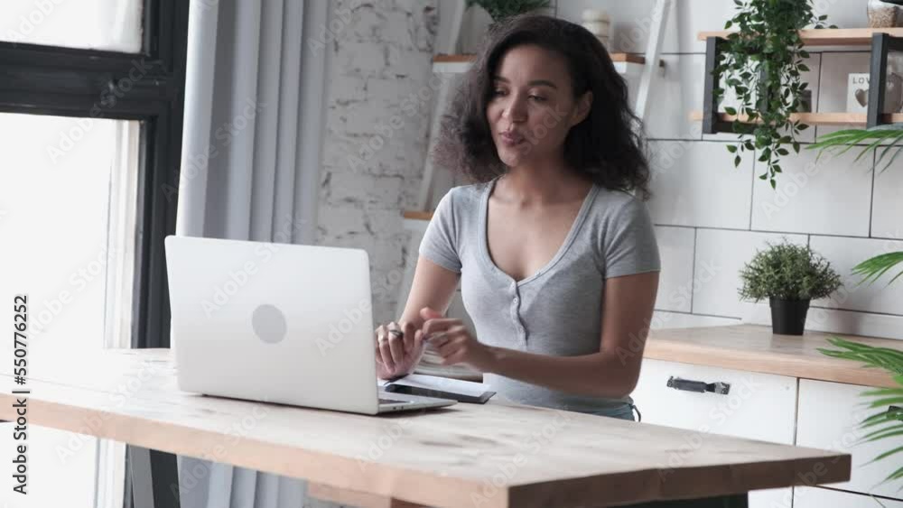 Remote meeting concept. Young african american female using laptop for video call, woman in casual wear talks online, involved video conference, female student learning on distance from home office Remote meeting concept. Young african american female using laptop for video call, woman in casual wear talks online, involved video conference, female student learning on distance from home office