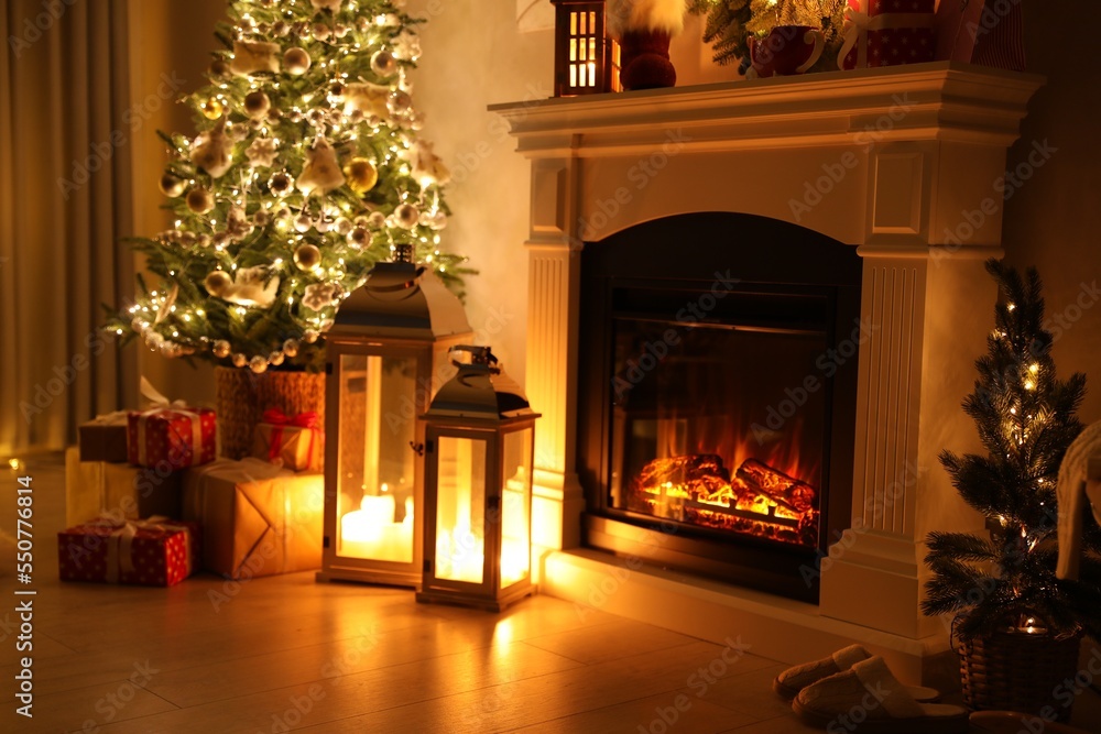 Beautiful fireplace, Christmas tree and other decorations in living room at night. Interior design Beautiful fireplace, Christmas tree and other decorations in living room at night. Interior design