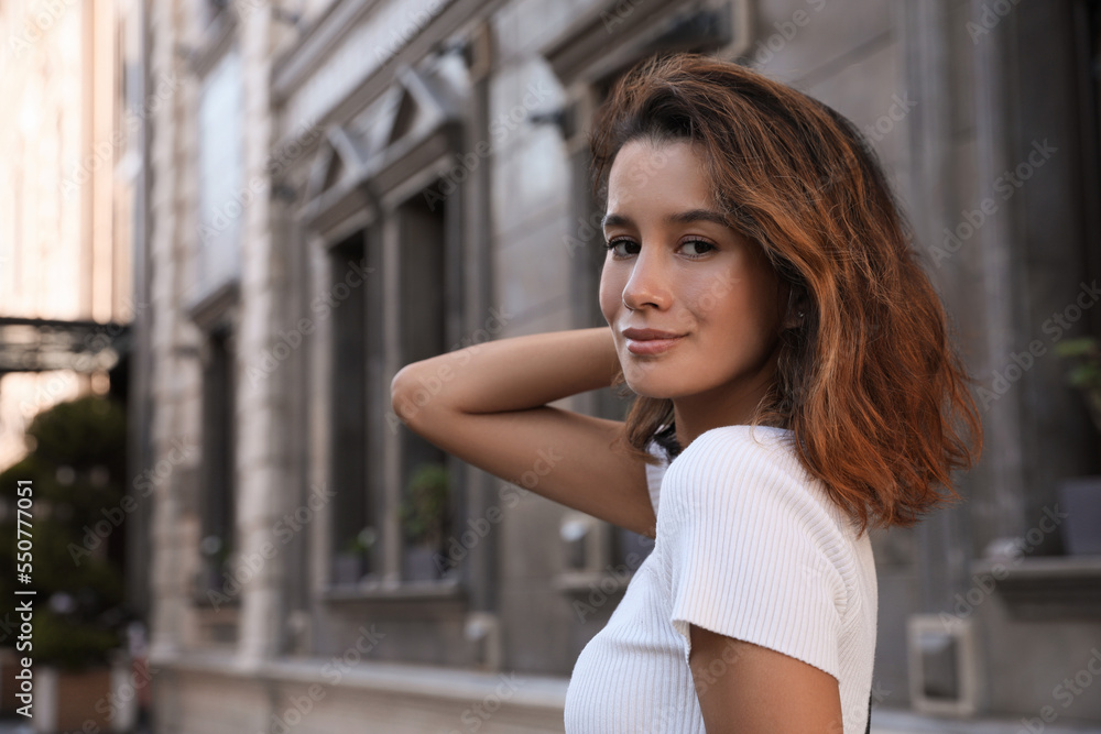 Portrait of beautiful young woman on city street