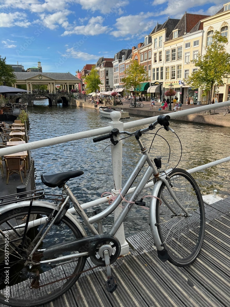 Beautiful view of bicycle on pedestrian bridge near canal in city
