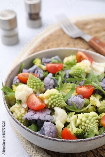 Delicious salad with cauliflower and tomato served on white table, closeup
