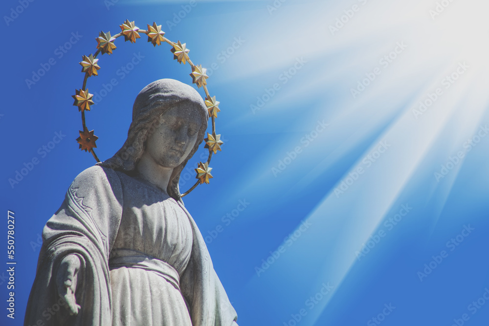 Obraz premium Virgin Mary against blue sky. Fragment of ancient statue. Religion, faith, Christianity concept.