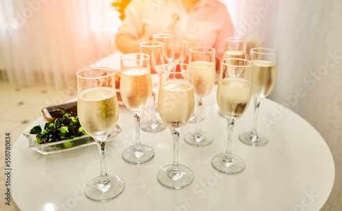 The waitress distributes sparkling white wine to the guests.