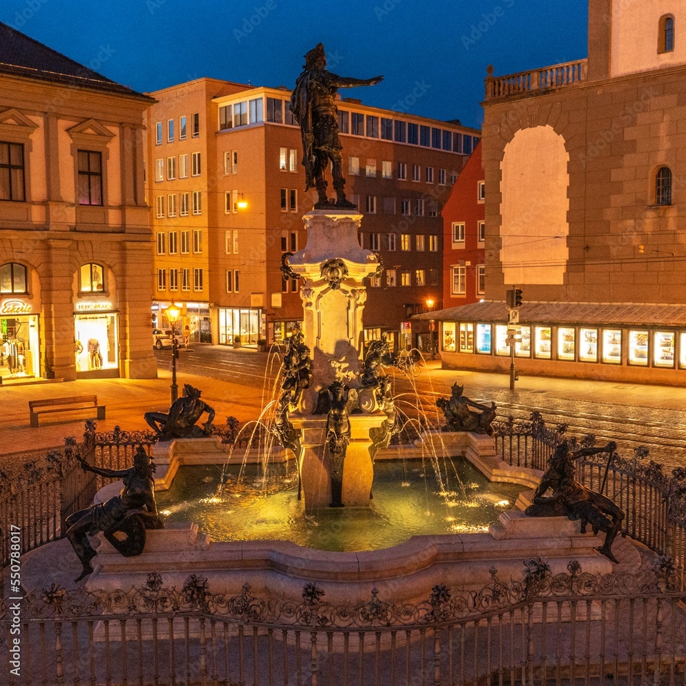 Fototapeta premium Romantische Abendstimmung am Augustusbrunnen am Augsburger Rathausplatz
