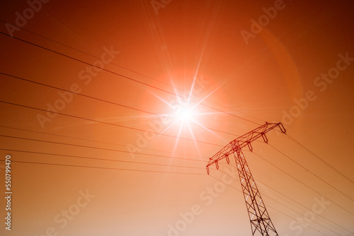 scorching summer sun on red sky and power line wires