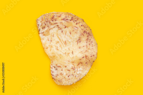 Crispy taro chip on yellow background.