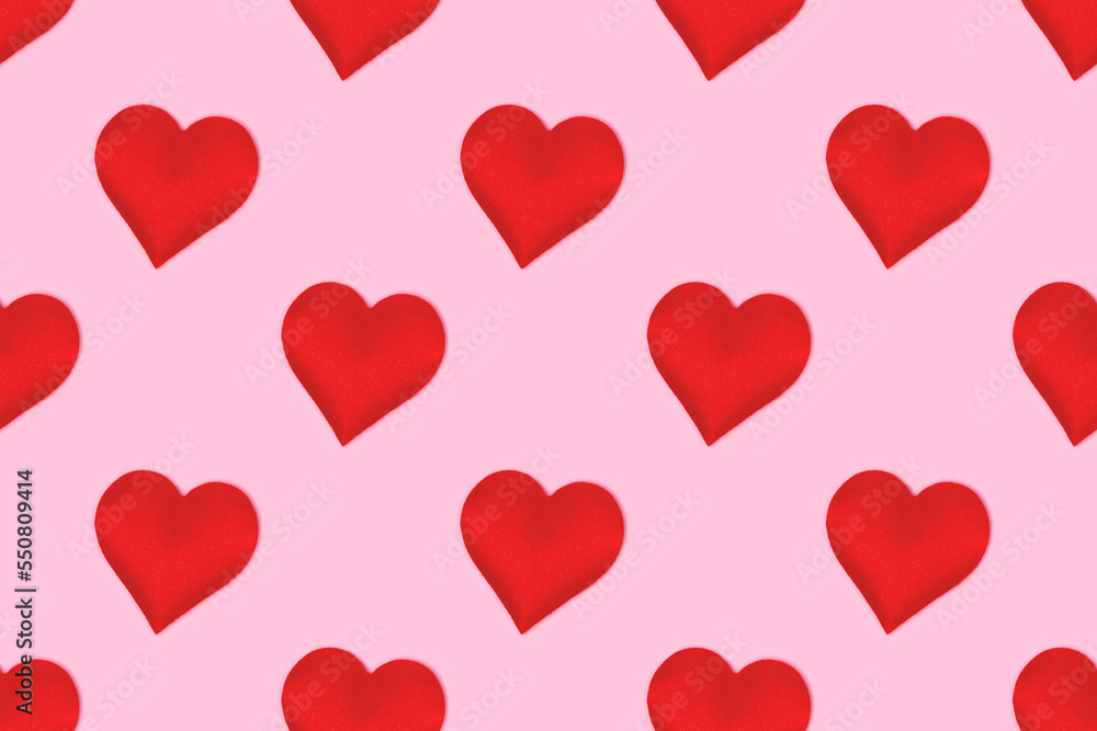 Repetitive pattern made of red hearts. Minimal concept on a pink background.