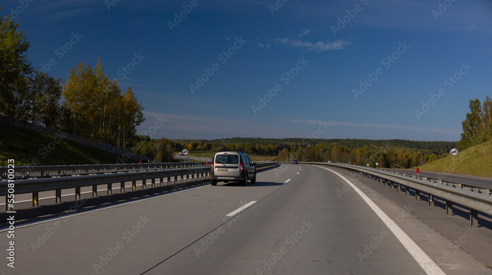 Naklejka premium Highway wide road, transport and blue sky with clouds on a summer day