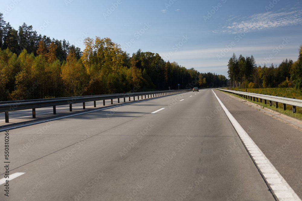 Naklejka premium Highway wide road, transport and blue sky with clouds on a summer day