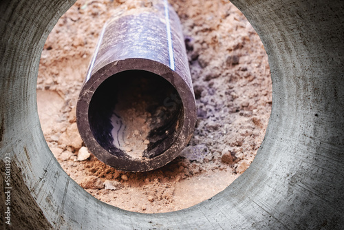 Modern water supply and sewerage system. Underground pipeline works. Water supply and wastewater disposal of a residential city. Close-up of underground utilities. View from the big pipe.