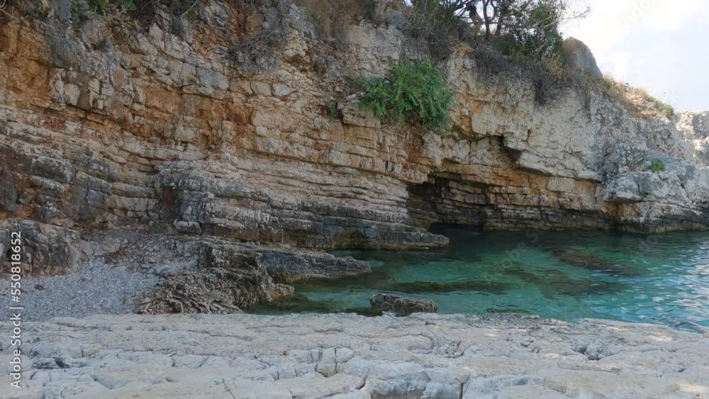 Bataria beach, Pristine rocky beach with Turquoise clear water, Kassiopi, Corfu Island - Panning shot Bataria beach, Pristine rocky beach with Turquoise clear water, Kassiopi, Corfu Island - Panning shot