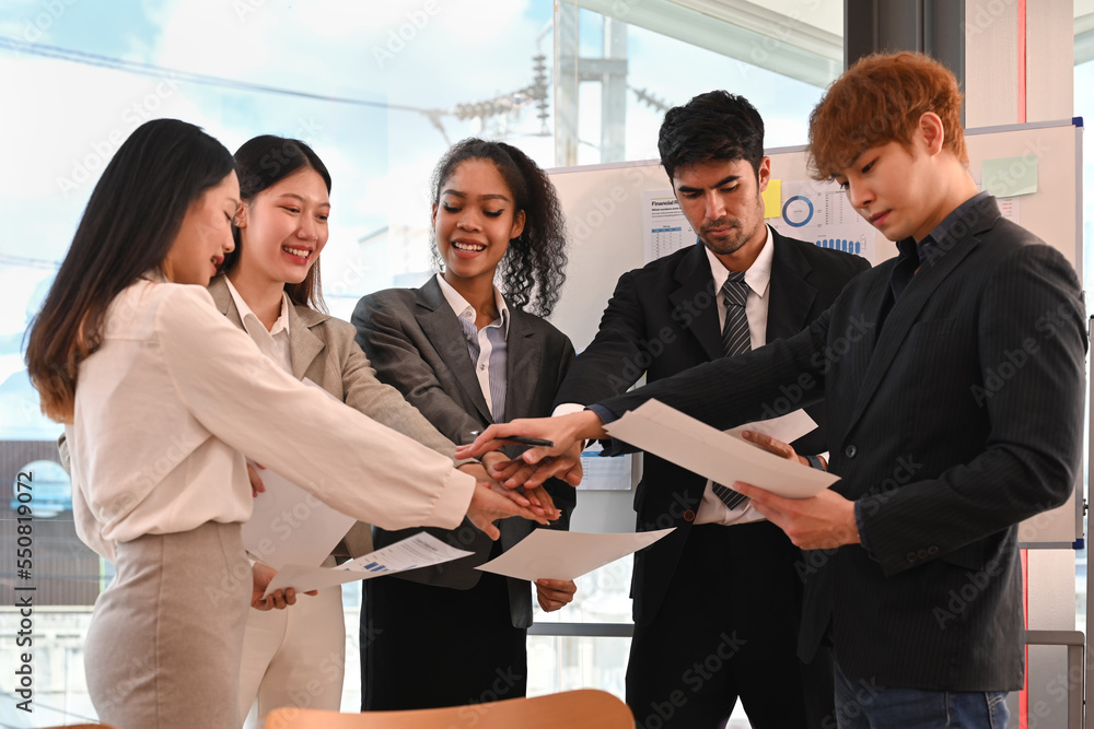 Successful business team putting hands together, showing support and unity during meeting in corporate meeting Successful business team putting hands together, showing support and unity during meeting in corporate meeting