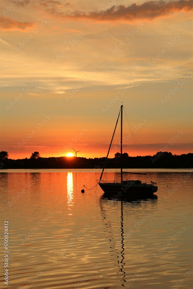 Segelboot im Abendrot bei Sonnenuntergang im Sommer an der Schlei.